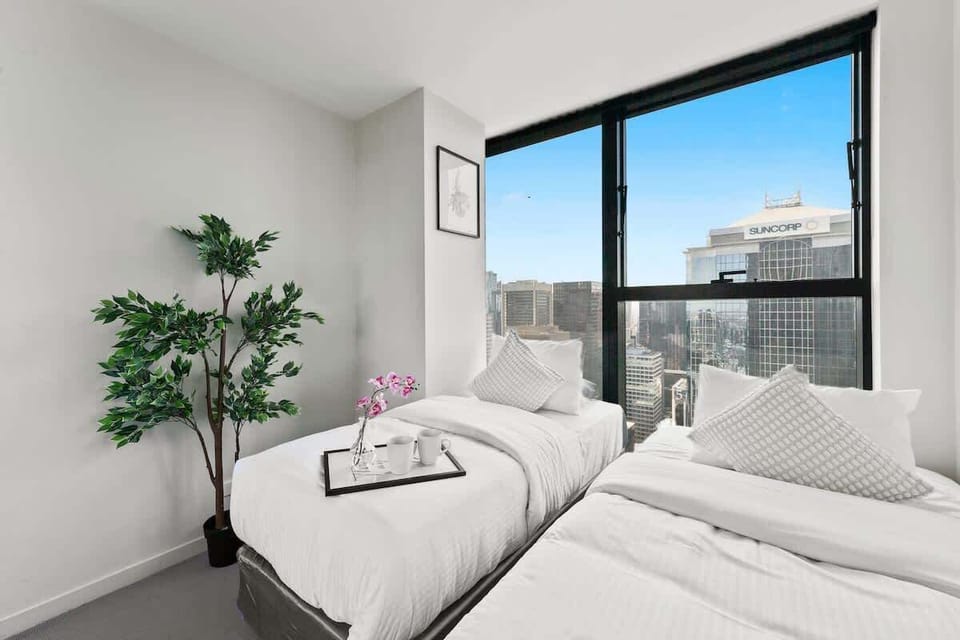 A second bedroom with a 2 single beds & plush pillows.
