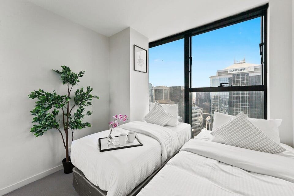 A second bedroom with a 2 single beds & plush pillows.