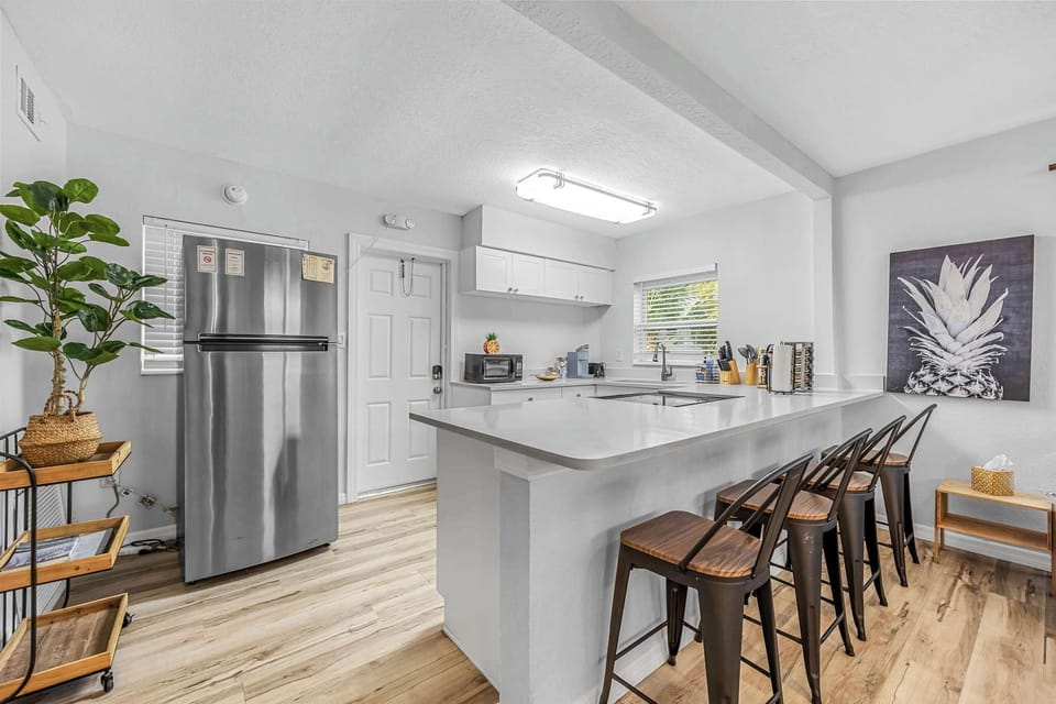 Modern kitchen with a large white island and seating for four.