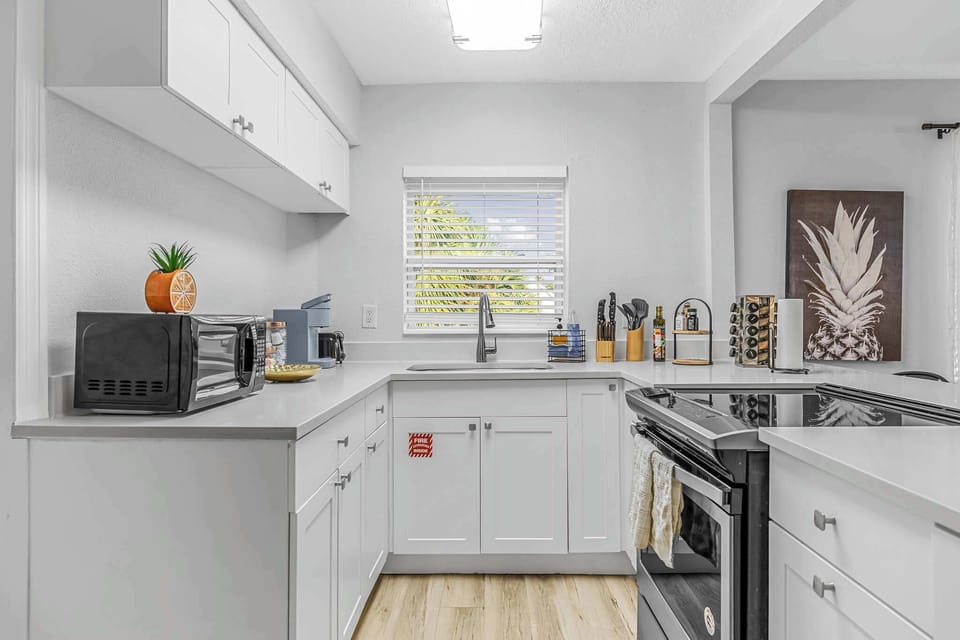 Modern kitchen with white cabinetry and natural light from the window