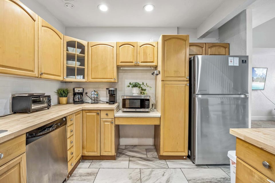 Modern kitchen with light wood cabinets and stainless steel appliances