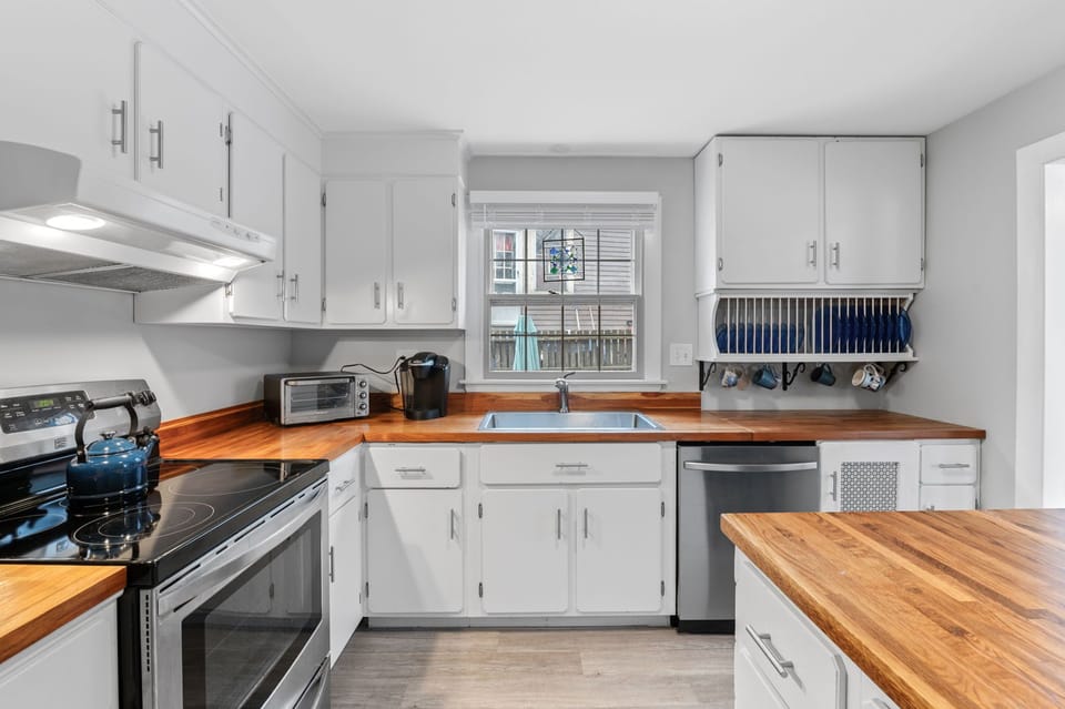 Bright kitchen with stainless steel appliances and a large refrigerator. 




