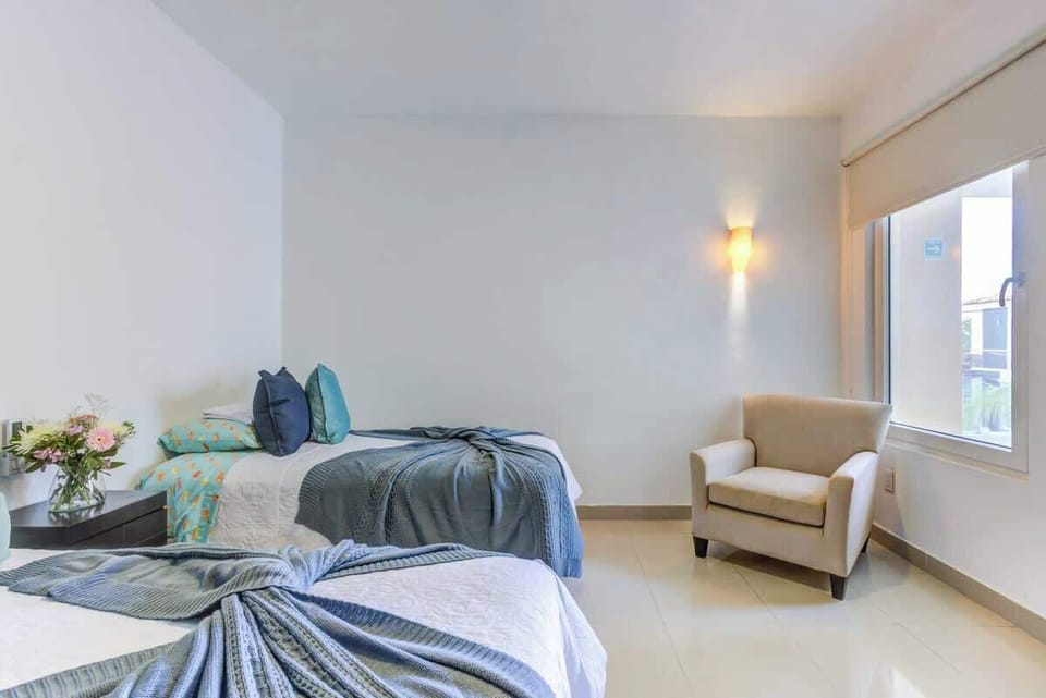 Bedroom 2 has 2 single beds and an armchair