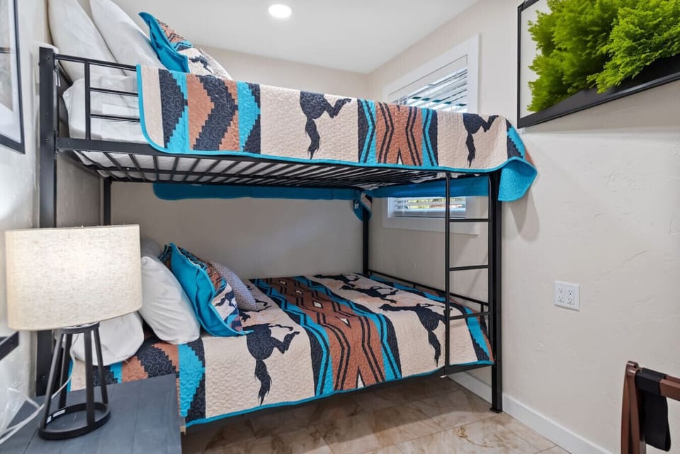 Bedroom 6 offers a spacious queen over queen bunk bed, perfect for families or groups looking for comfortable and cozy sleeping arrangements.