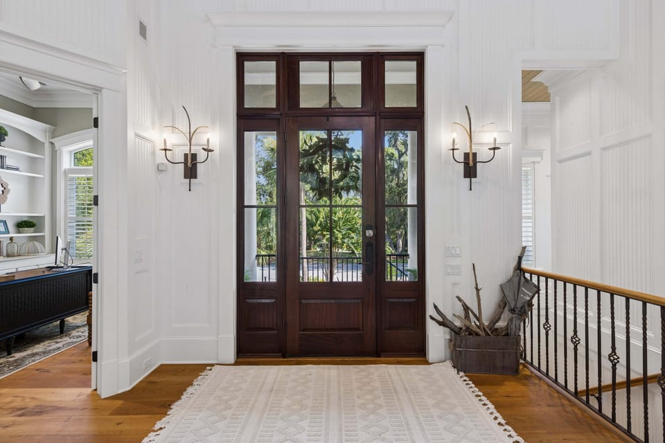 Step through solid mahogany doors and glass transoms that fill the entry with soft island light.