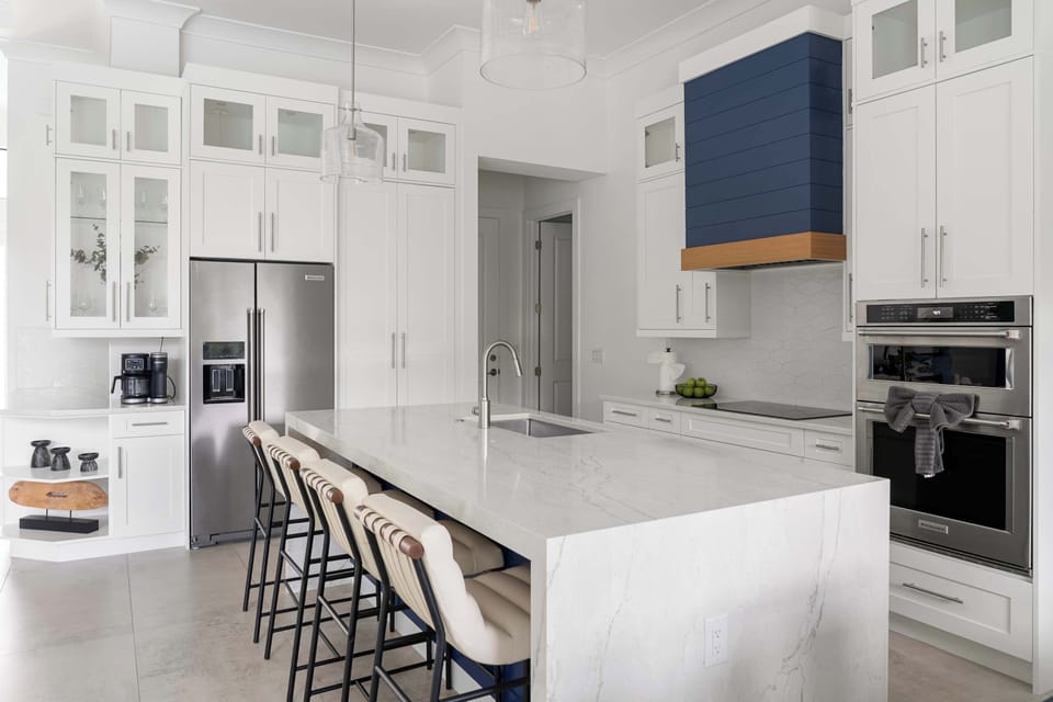 A kitchen made for gathering. Sleek stainless appliances, a waterfall island, and seating for the whole crew — cooking together has never looked this good.