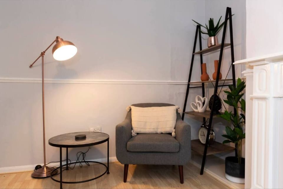Cozy up in this charming reading nook, featuring a comfy armchair, warm lighting, and stylish decor—perfect for relaxing with a good book.
