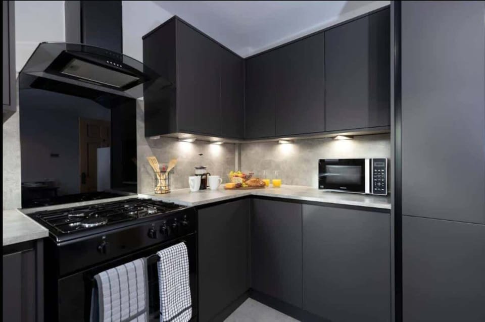 This modern kitchen features stylish cabinetry, bright under-cabinet lighting, and all the essentials for a convenient cooking experience.