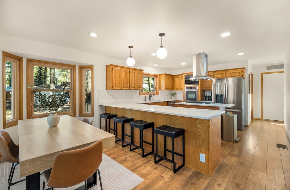 Stainless steel appliances and kitchen peninsula with quartz countertops