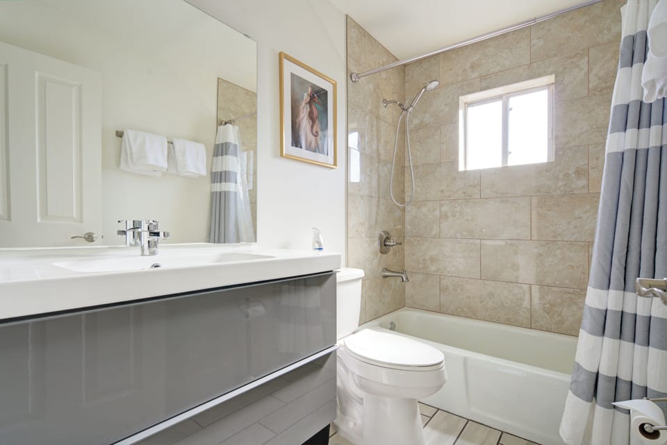 Main bathroom with tub/shower. Towels, hair dryer and body wash/shampoo/condinti