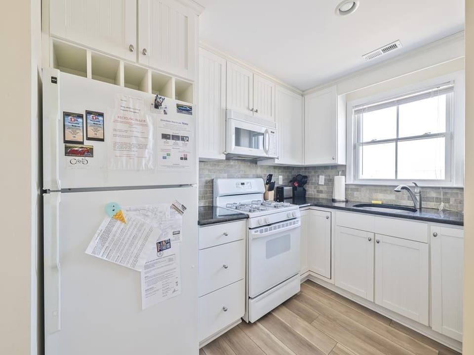 Step into a bright kitchen featuring white cabinetry and modern appliances, perfect for family meals.