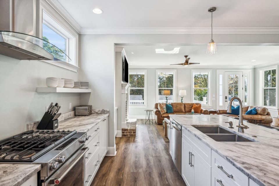 A fully stocked kitchen with stainless steel appliances, and 4 barstools for extra seating.