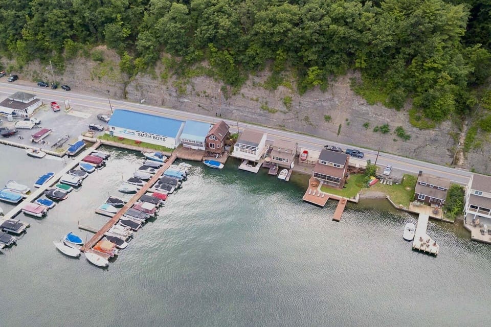 Nestled at the edge of a serene lake, this charming dock features a row of inviting, comfortable chairs, perfect for relaxing and enjoying the peaceful surroundings. The chairs, crafted from weather-resistant materials, are designed for comfort with 