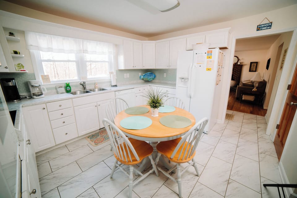 Fully equipped white kitchen with a cozy breakfast nook