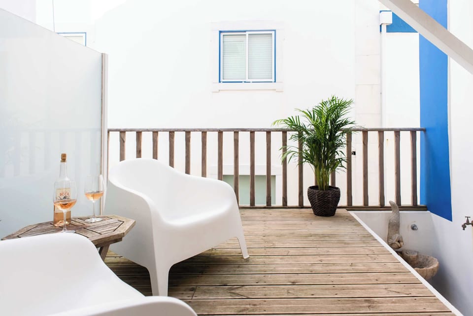Santo Antonio 1 relaxing balcony with comfortable seating and a touch of greenery.