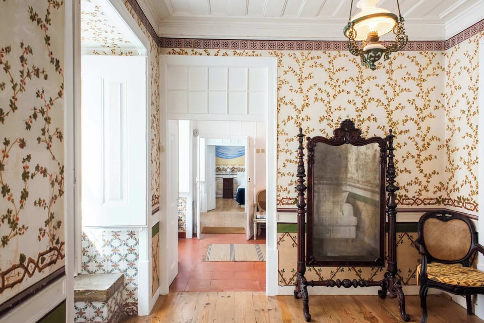 Santo Antonio 1 hallway with a vintage mirror and floral wallpaper, showcasing a blend of old-world charm and refined style.