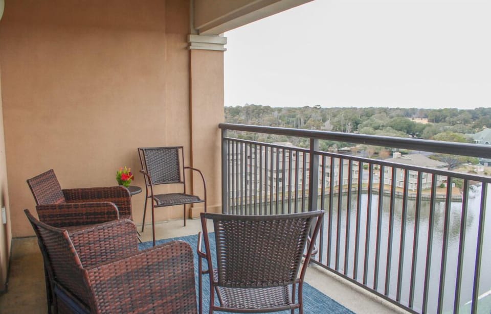Unwind on your private balcony with comfortable wicker seating and sweeping views over lush greenery.