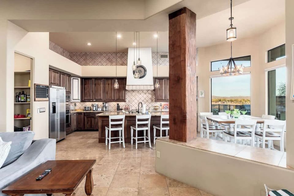 Gather around your spacious kitchen island with seating for three, where rich walnut cabinetry and modern appliances meet. Just steps away, your dining table overlooks serene water views through floor-to-ceiling windows.