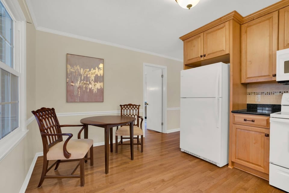 Convenience meets style. This kitchen features a full-sized refrigerator and easy access to the rest of the home, making it a top choice for families needing insurance housing or relocation rentals in Durham.