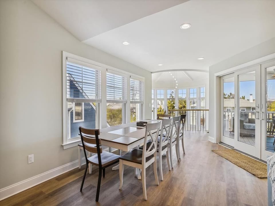 Bright dining area with large windows and seating for a group, ideal for enjoying meals with a view.