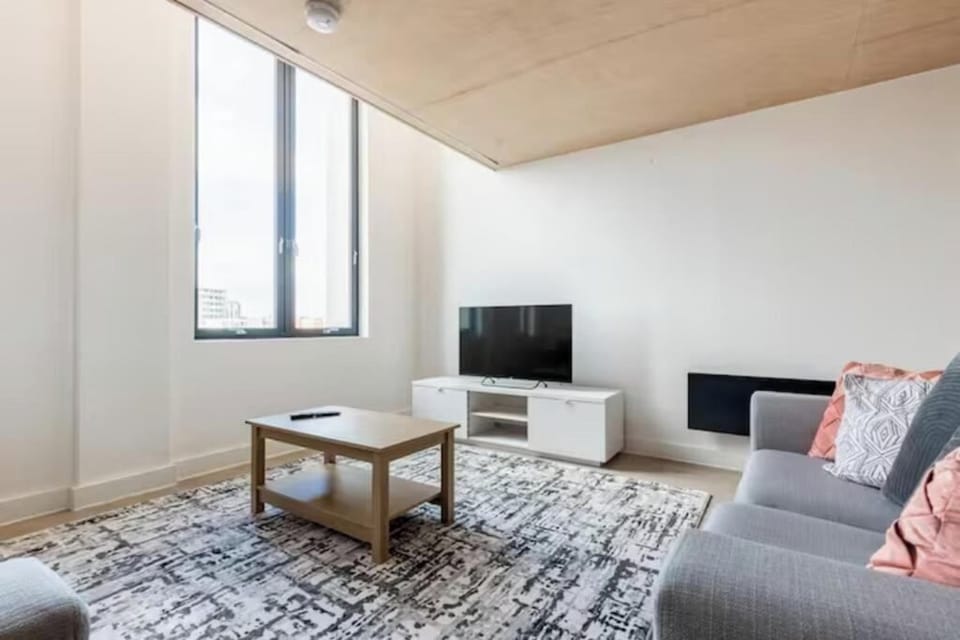 Floor to ceiiling window living room with sofas and TV