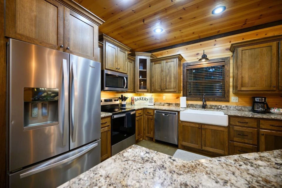 This kitchen has that perfect mix of upscale finishes—stainless steel appliances, granite countertops, wood ceiling beams, and plenty of counter space—that makes cooking feel like less of a chore and more like part of the vacation vibe.