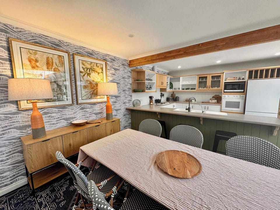 Six person dining table in dining area next to kitchen