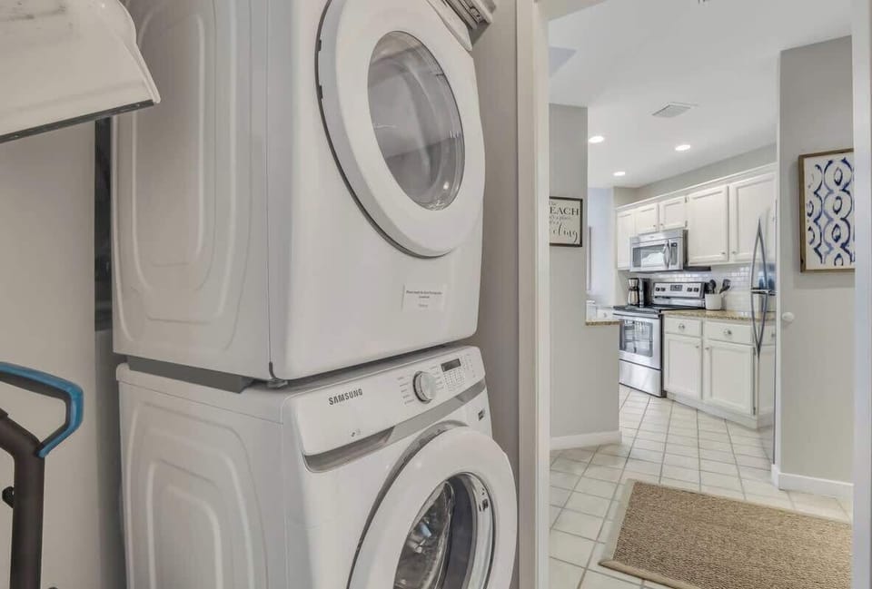 A dedicated in-unit laundry area featuring a high-efficiency washer and dryer.