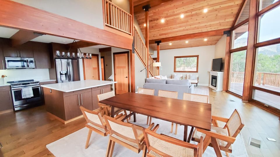 Spacious open-concept interior with a modern kitchen, elegant dining area, and warm wooden accents.