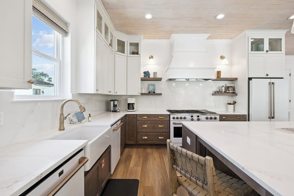 Your dream kitchen awaits with gleaming marble countertops, professional-grade appliances, and warm wood tones. Sunlight streams through large windows, illuminating the perfect space to create memorable meals during your stay.
