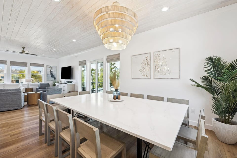 Gather around this elegant dining table where your group can share memorable meals together in a bright, beautifully designed space with coastal charm and comfortable seating for ten.