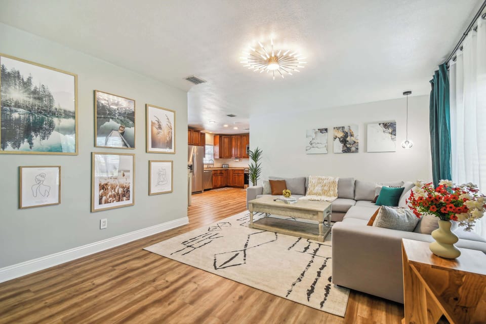 Spacious Clearwater rental living room with designer gallery wall, sectional sofa, and open-concept layout ideal for large group gatherings 