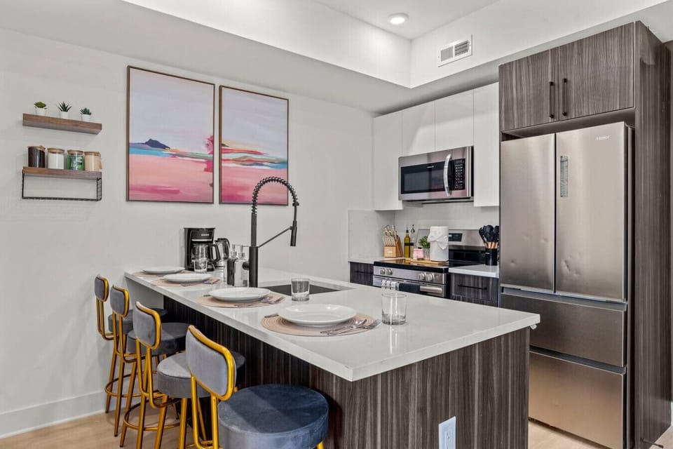 Dining area that seats 4 people with plates, mugs, and stainless steel flatware.