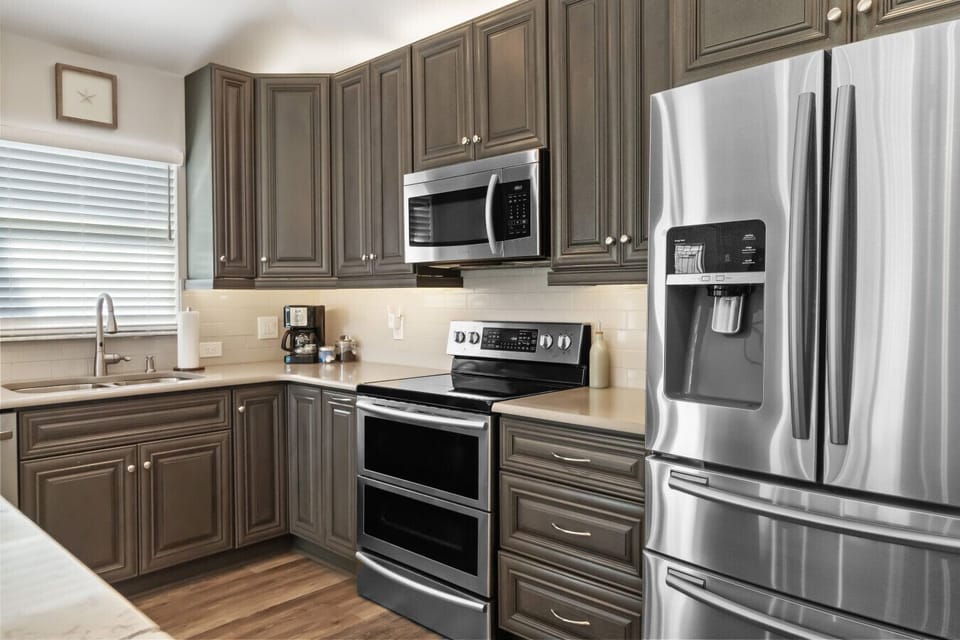 This open, airy kitchen is perfect for cooking, gathering, and sipping your favorite blend from the corner coffee bar. ☕🌴