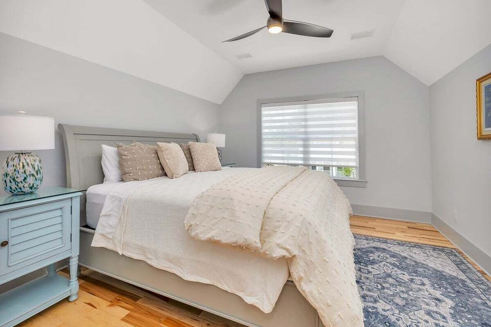 Bedroom with gray bed and vaulted ceiling