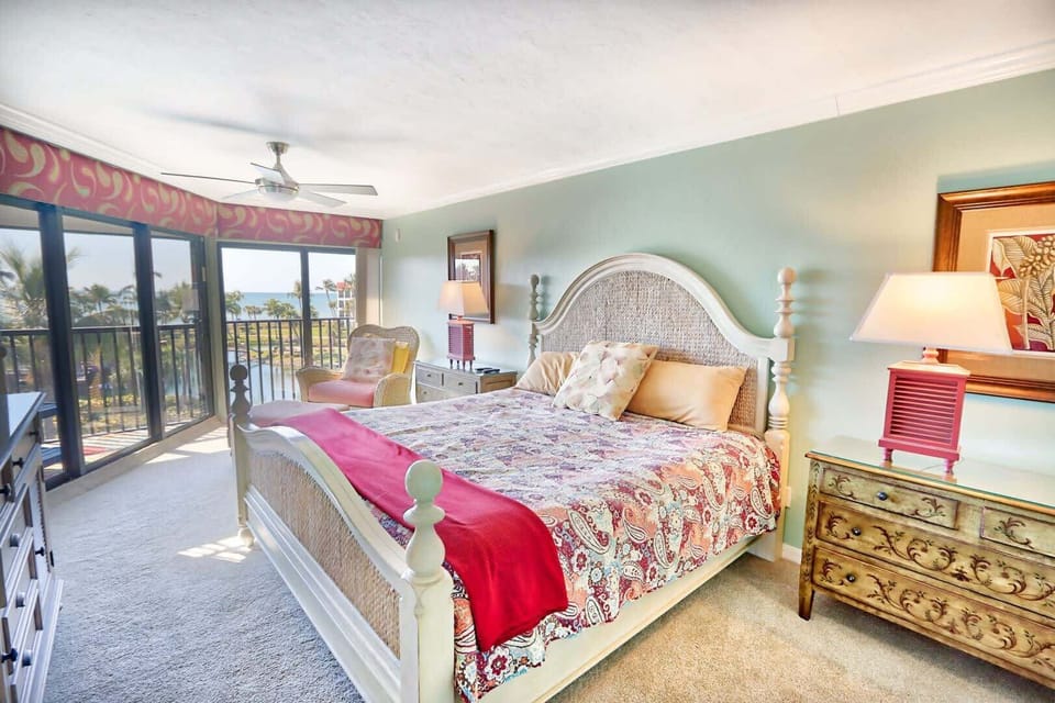 King bed with ensuite access to both the patio and primary bathroom, which features a large vanity and renovated walk-in shower.