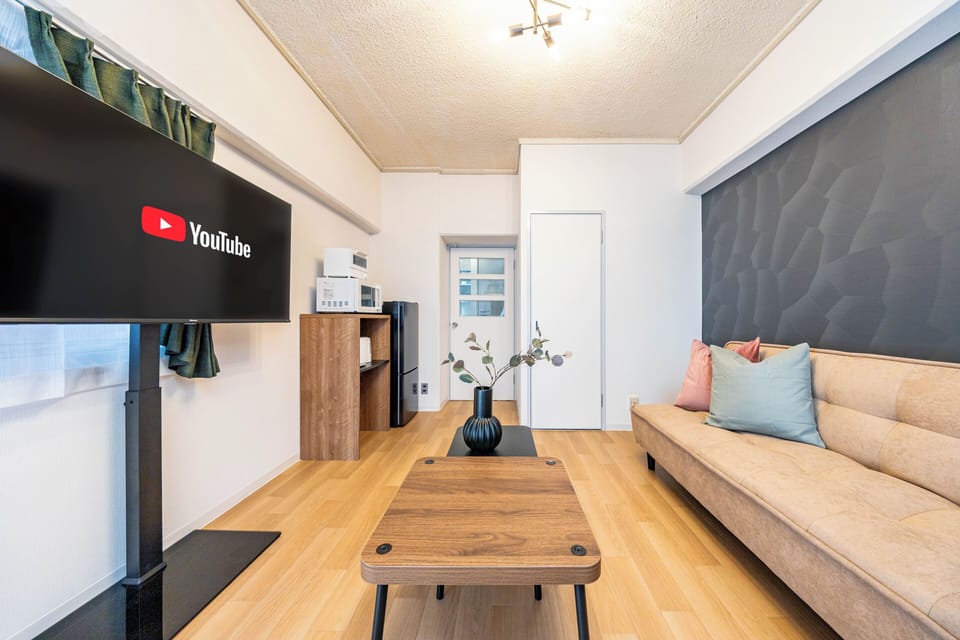 Deluxe Apartment, Balcony, City View | Living area | 50-inch flat-screen TV with cable channels