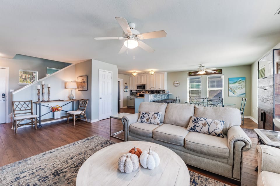 Relax in your spacious open-concept living area with comfortable seating and coastal charm throughout.