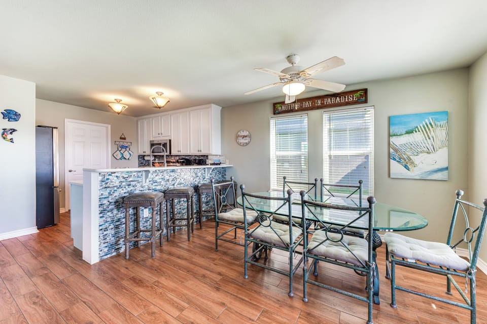 Gather around your open kitchen and dining space, where coastal charm meets comfort for memorable meals together.