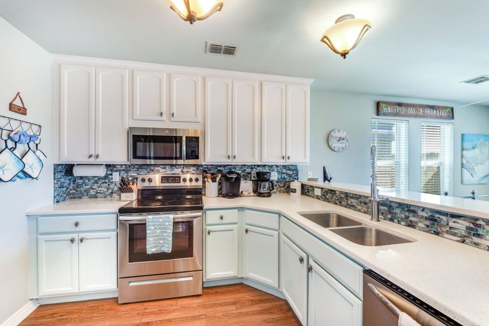 Your fully equipped kitchen awaits with coastal charm, featuring beautiful blue tile backsplash and everything needed for memorable meals.