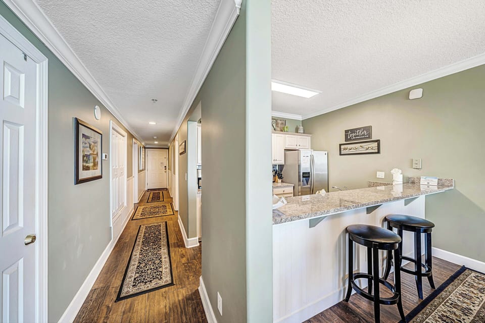There is a dining table, perfect for enjoying a meal or playing a game, as well as additional breakfast bar seating.