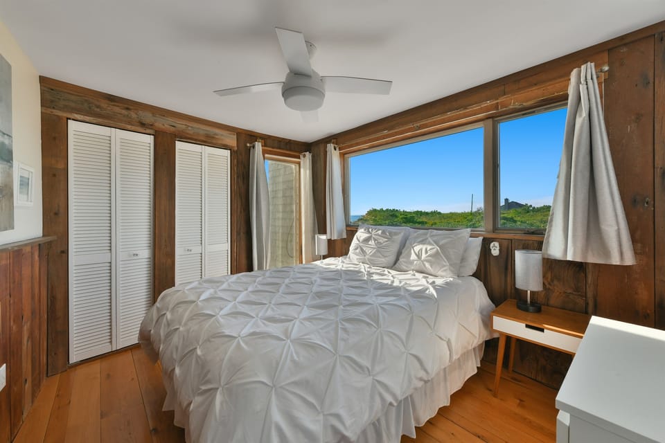 Third bedroom on the ground level, right side, filled with natural light and a peek of the ocean.