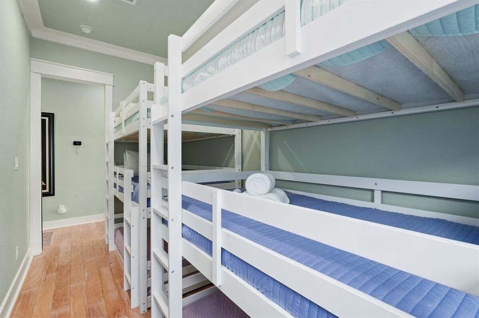 Spacious bunk bedroom with custom built-in bunks, hardwood floors, and sleeping accommodations for large vacation groups.