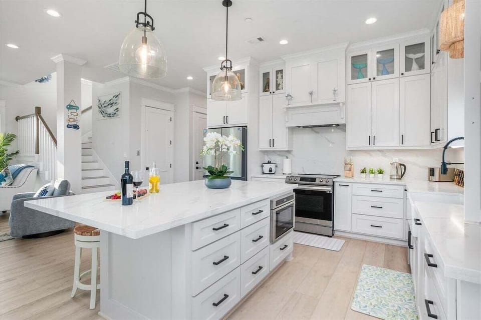 Spacious gourmet kitchen with double ovens, quartz countertops, custom cabinetry, and high-end stainless steel appliances.