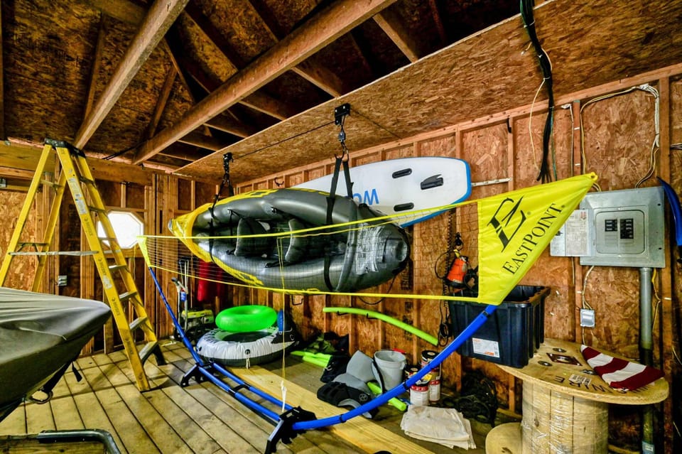 Boathouse storage area equipped with kayaks, paddleboards, and recreational gear for lake activities.