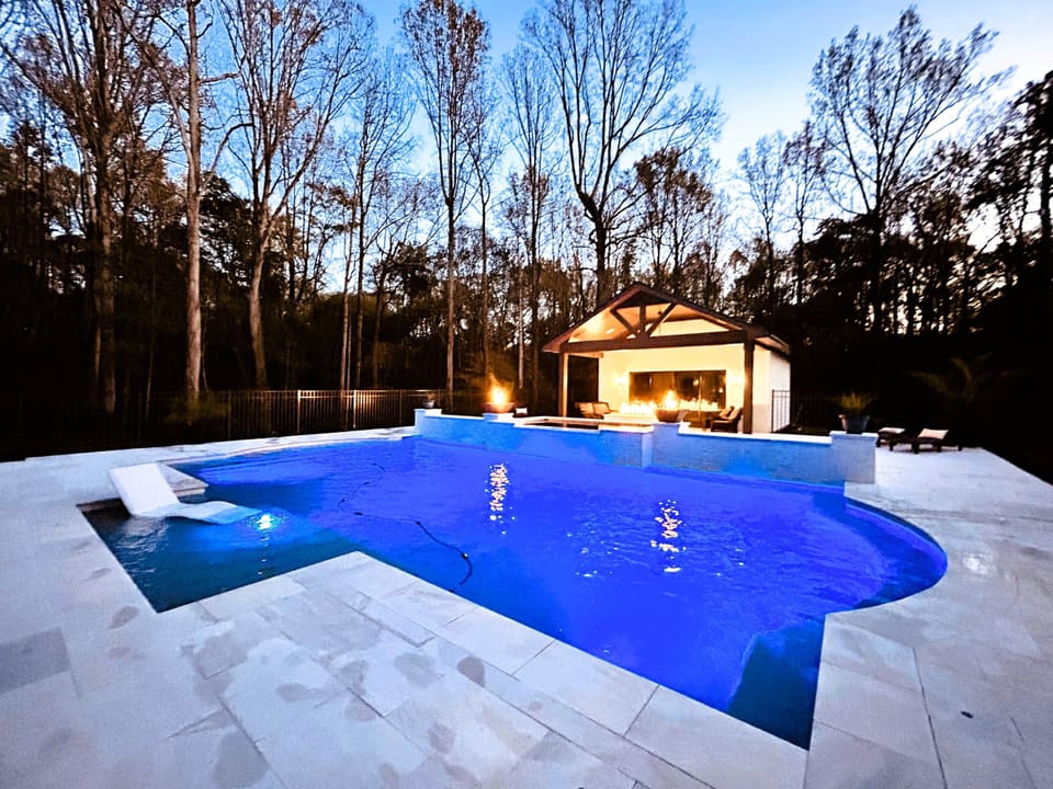 Oversized pool with tanning ledge and waterfalls.