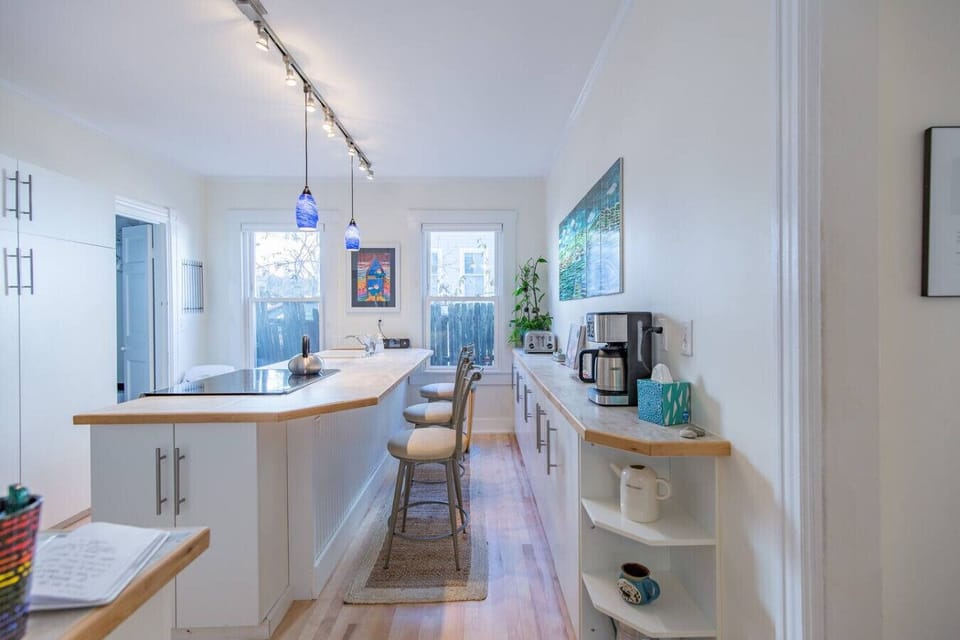 Comfortable kitchen with counter-top stools, a peninsula stovetop and oven, and dishwasher