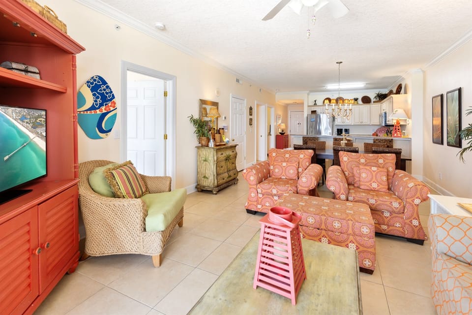 Relax in your vibrant living space with comfortable seating, coastal artwork, and open views to the kitchen.