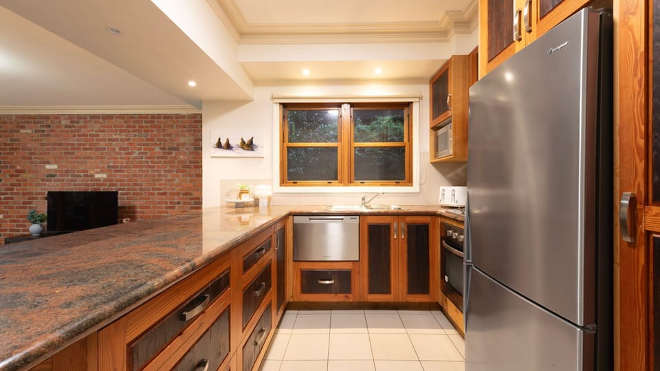 Classic Timber Kitchen: U-shaped kitchen complete with premium stone benchtops and stainless steel appliances.