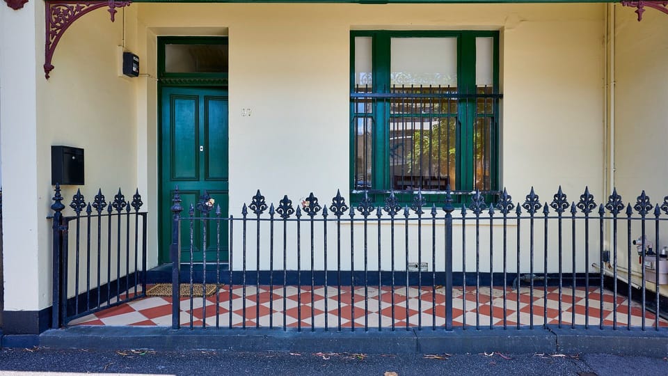 Heritage Facade: Charming traditional entrance adorned with classic iron lacework and a statement green door.